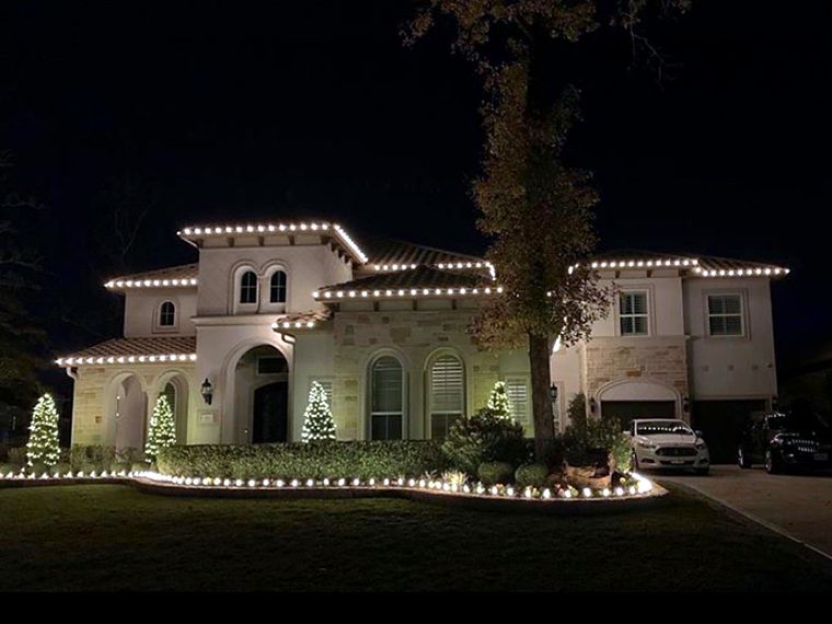 Stucco home with warm white roofline lights
