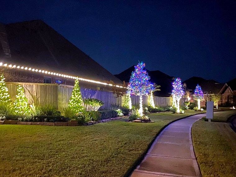 Walkway with lit trees and roofline lights